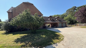 A large brick house with a garage, a covered porch, and a gravel driveway.