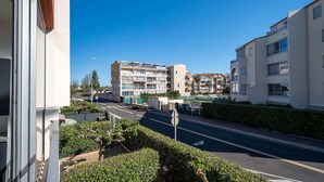 A multi-story residential building with balconies, a clear sky, and a road in the foreground. - Apartment in Agde near Beach & Heated Pool (Agde)