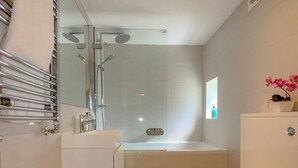 A modern bathroom with a bathtub, toilet, and a glass-enclosed shower area. - Pass the Keys | Central 2 Bed 2 Bath Duplex (London)