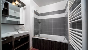 Une salle de bain moderne avec une douche, un lavabo et un miroir.