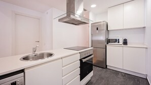 A modern kitchen with white cabinetry, stainless steel appliances, and a sleek design.