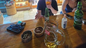 En bardisk med en trätopp, en flaska Carlsberg-öl, ett ölglas, en flaska maltöl och en ölsejdel.