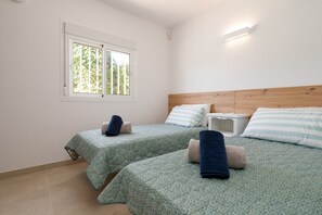 A bedroom with two beds, a window, and a bedside table. - Villa Blue Skies - Calahonda (Sitio de Calahonda)