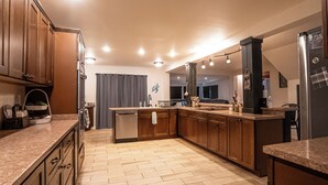 Une cuisine moderne avec des meubles en bois, un îlot central et un lave-vaisselle encastré.