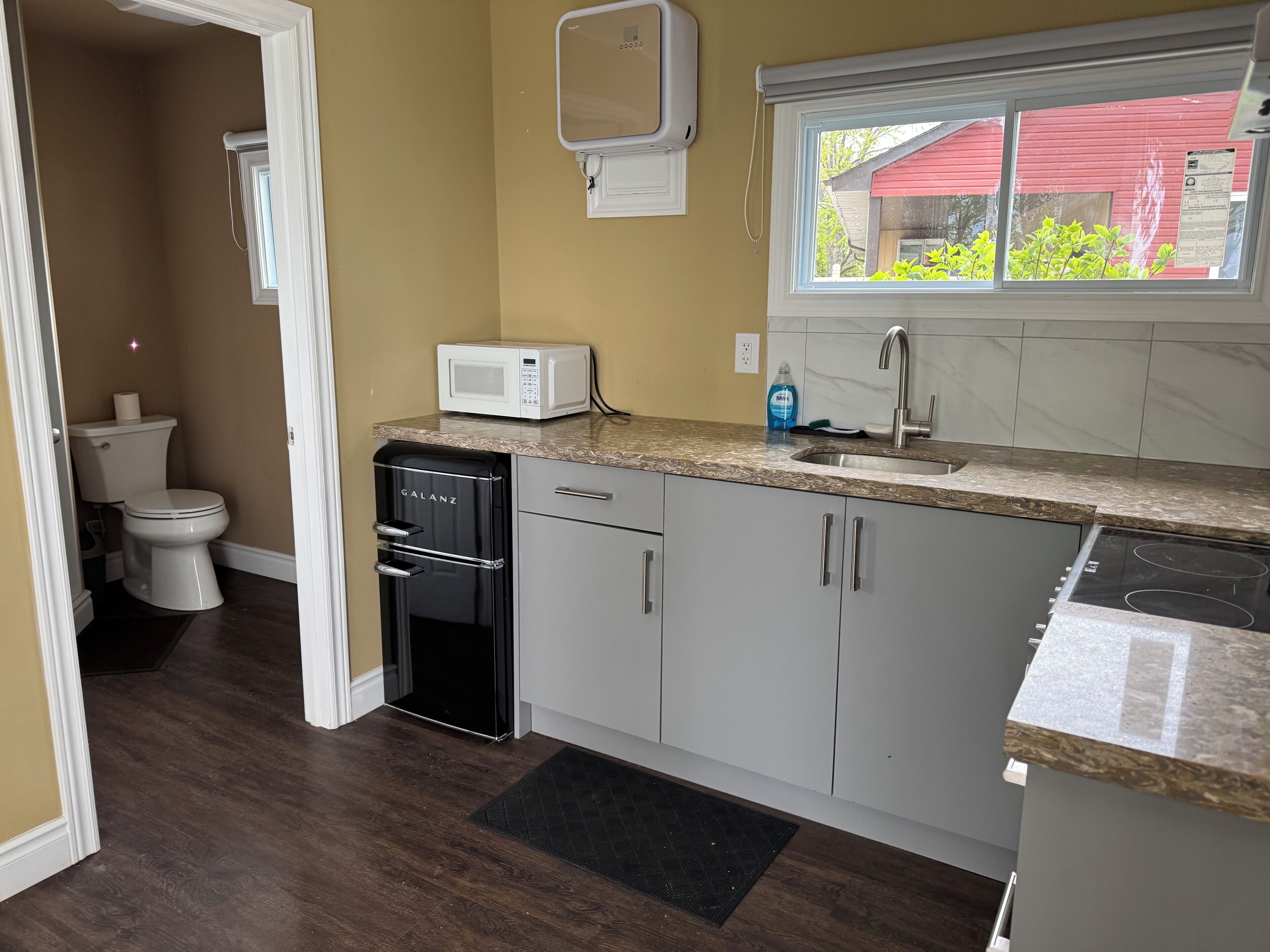 A compact kitchen with a microwave, sink, and dishwasher.