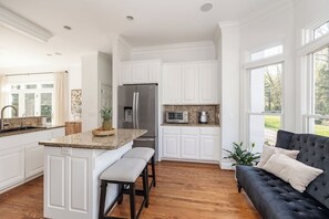 Modern kitchen with a central island, stainless steel appliances, and a casual dining area.