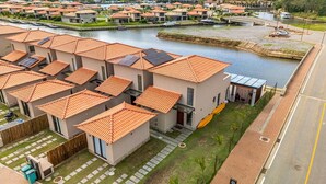 A residential area with modern houses, a canal, and a bridge.
