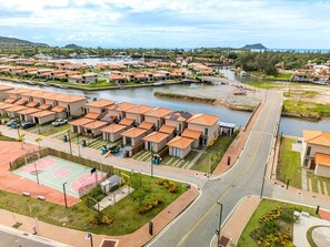 Un barrio residencial con casas, una cancha de baloncesto y un río.