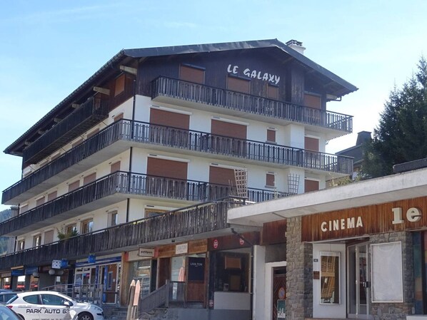 A multi-story building with balconies, a cinema, and a restaurant named 'petitpois' and 'LIVATOM'.