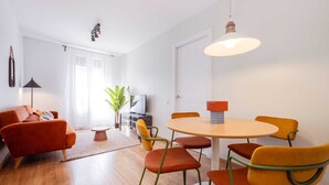 Ein modernes Wohnzimmer mit einer Couch, einem Couchtisch und einem Essbereich mit Stühlen und einem Tisch.