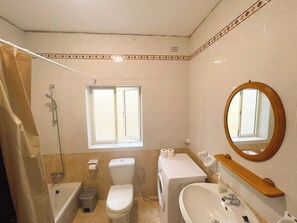 Een haardroger, handdoeken, zeep, toiletpapier