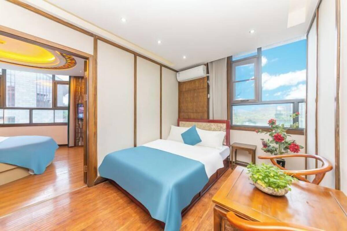 Ein Hotelzimmer mit Bett, Schreibtisch, Stuhl, Fenster und Blick auf die Stadt.