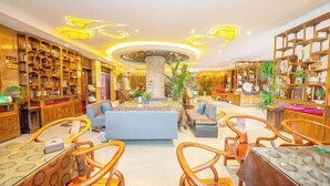 A spacious lobby with a central seating area, wooden bookshelves, and a decorative ceiling. - Xijingli Hotel (Yuzhong Ancient City) (Langzhong)