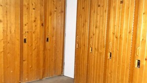 Un couloir aux murs recouverts de lambris en bois et doté d’un sol en béton.