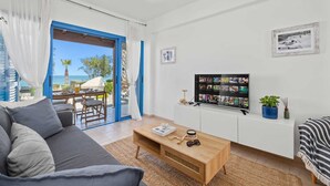 Ein modernes Wohnzimmer mit Sofa, Couchtisch und Fernseher, der eine Fotowand zeigt.