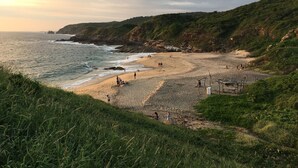 A beach with people, a rocky coastline, and greenery. - Casa Monte Pacifico, your haven of serenity between beach and rainforest. (San Agustinillo)