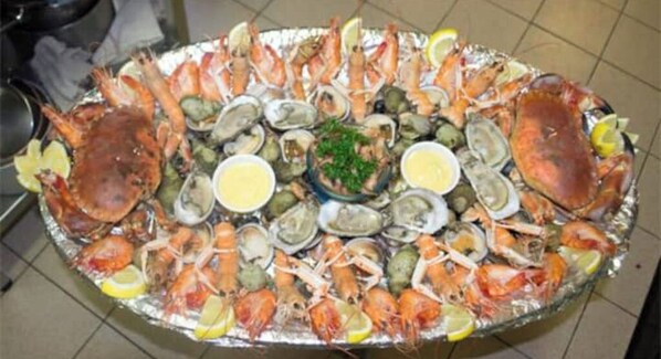 A seafood platter with various shellfish and crustaceans, garnished with lemon slices and accompanied by small bowls of sauce. - Lovely Traditional Manor new 2025 Pool (Group Up to 26x) (Mesnil-en-Ouche)