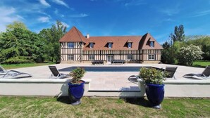 A large, two-story Tudor-style house with a symmetrical facade, a central entrance, and a swimming pool in the backyard. - Lovely Traditional Manor new 2025 Pool (Group Up to 26x) (Mesnil-en-Ouche)