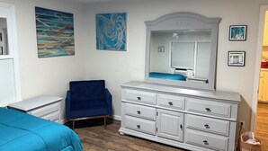 A bedroom with a bed, a dresser, a chair, and artwork on the walls. - Charming 2-bdrm home in Little Rock with WiFi and AC (Little Rock)