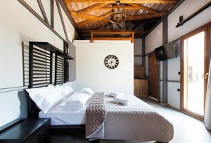 Un dormitorio con una cama, un reloj en la pared y una televisión.