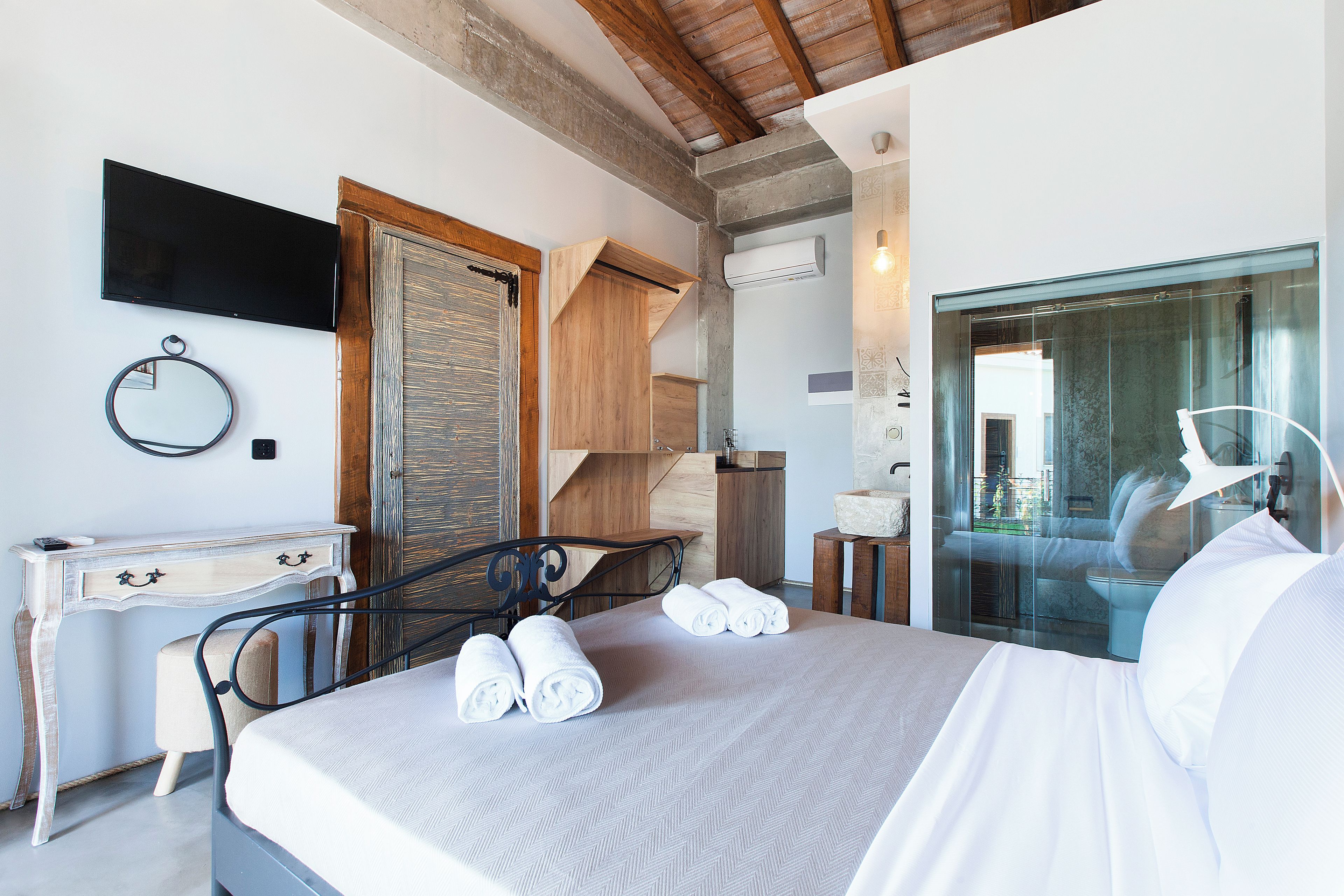 Ein Schlafzimmer mit Bett, Schreibtisch, Stuhl, Spiegel und Fernseher.