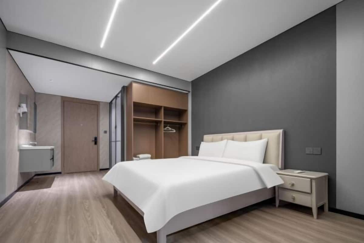 Un dormitorio moderno con una cama grande, mesitas de noche, un armario y un vestidor.
