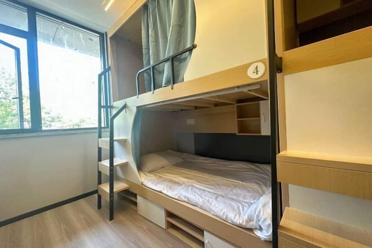 Habitación con literas, una ventana y el número 4 en la pared.