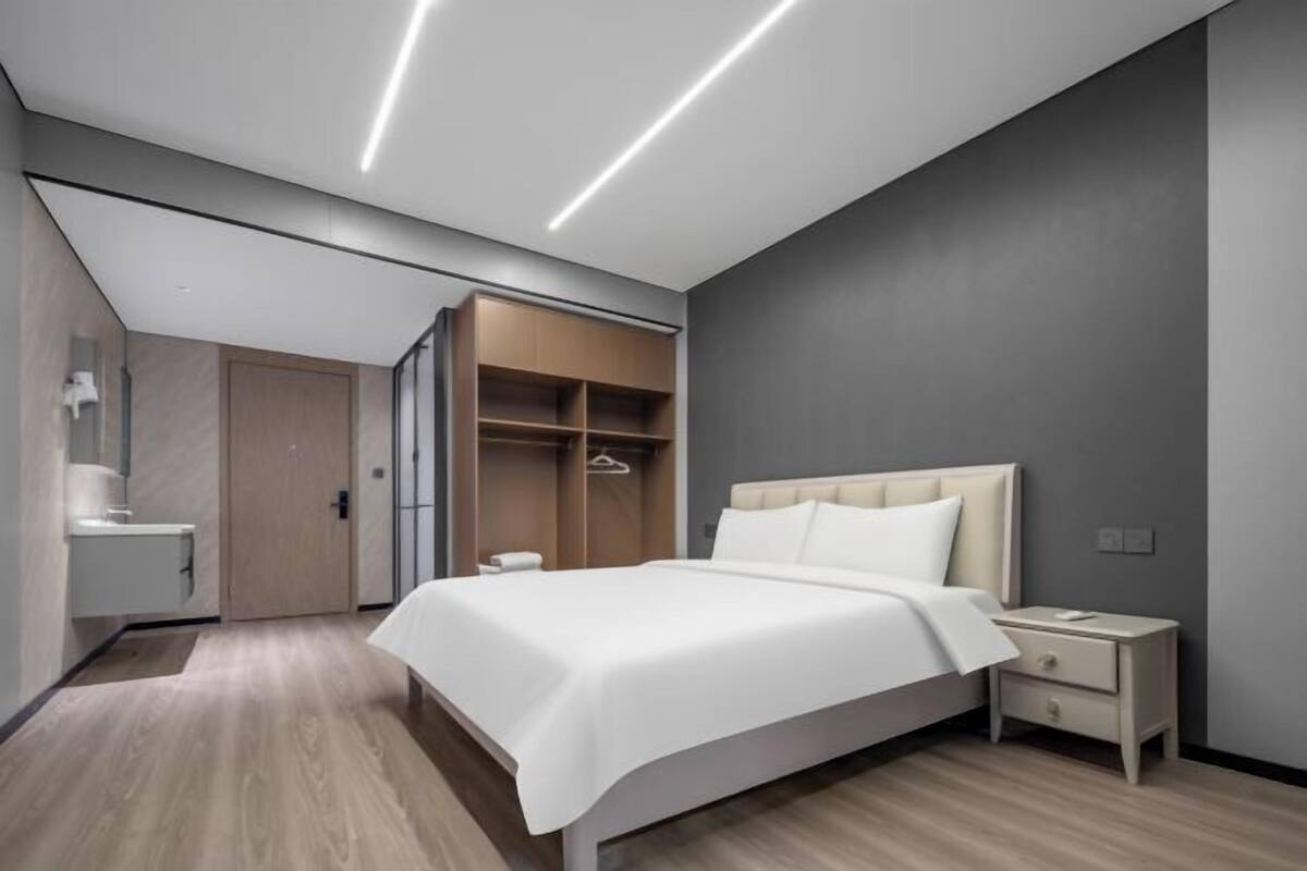 Un dormitorio moderno con cama, mesita de noche y armario empotrado.