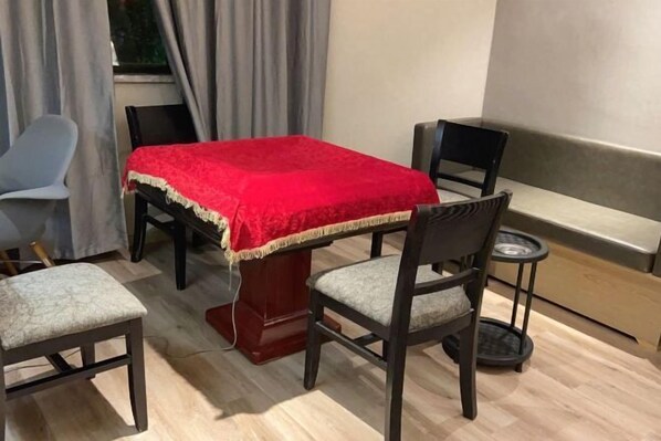 A dining area with a table covered by a red cloth, four chairs, a small round table, and a bench. - Waiting Hotel (Cao'An Road) (Shanghai)