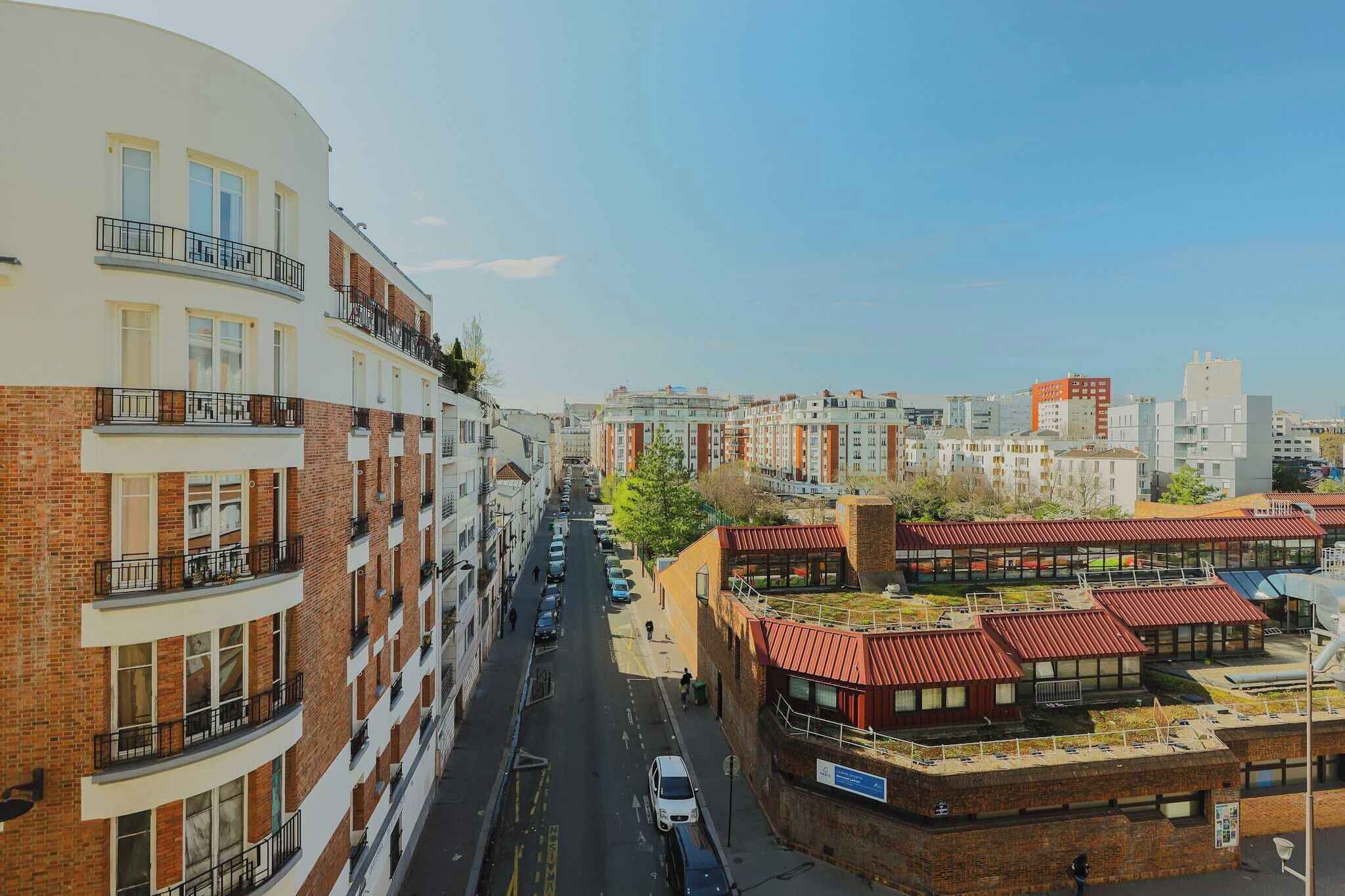 Un edificio residenziale a più piani con balconi, vista sulla strada e un mix di architettura moderna e tradizionale.