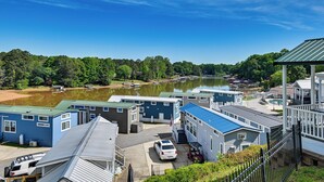 Een jachthaven met boten, een meer en stacaravans met een blauw dak.
