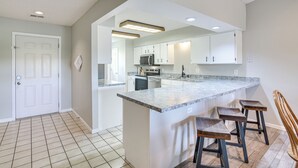 A modern kitchen with white cabinets, a granite countertop, and a built-in microwave. - Indoor Pool Access: Family Condo 1 Mi to 76 Strip! (Branson)