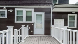 A house with a dark brown exterior, white trim, and a wooden deck with white railings. - New England Traditional x Modern, 5 Bedrooms, Office, 8ppl (Quincy)