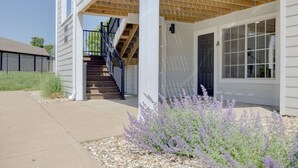 A two-story building with a covered porch, a staircase, and a front door.