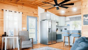 A cozy cabin interior with a dining area, kitchen, and seating space. - Pops Cozy Cabin w/ an incredible valley view. Gas firepit, full kitchen and more (Fancy Gap)