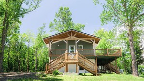 A lodge with a central wooden staircase, a covered deck, and a front porch. - Pops Cozy Cabin w/ an incredible valley view. Gas firepit, full kitchen and more (Fancy Gap)