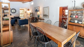 Eine geräumige Küche mit einem Holzespeisetisch, Stühlen und einem Einbauschrank mit Geschirr.
