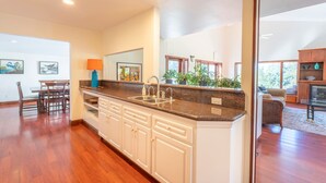 A modern kitchen with granite countertops, white cabinetry, and a large island. - Family Night's Rest | Game Room | Fort Bragg (Fort Bragg)
