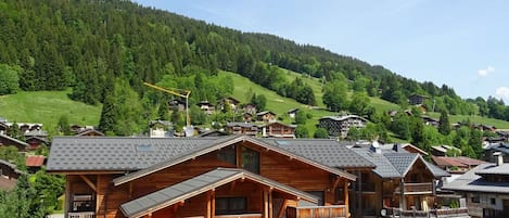 A wooden building with a restaurant named "Le Cuvée" and a sign for "Pizza & Pasta".