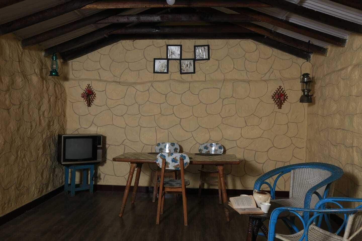 Un coin repas au style rustique, avec un mur en pierre, des meubles en bois et un téléviseur.