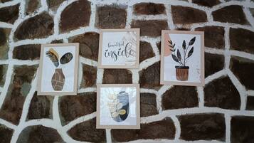 Four framed artworks on a stone wall.