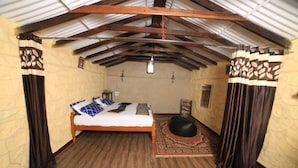 Ein kleiner, gemütlicher Raum mit einem Holzbett, einem Teppich und Vorhängen.