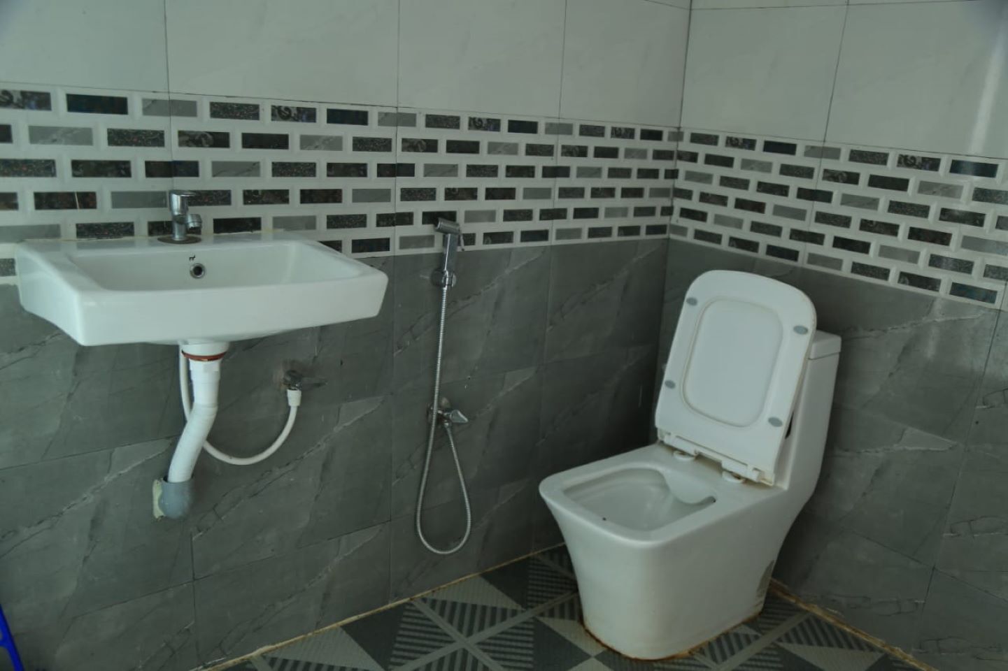 Une salle de bain avec un lavabo blanc, une douche et des toilettes.