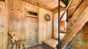 A wooden interior with a wooden chair, a wooden staircase, and a door with a wreath. - Chalet Zimbablick in Bartholom Berg (Bartholomaeberg)