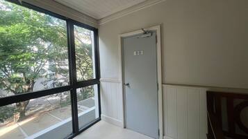 A room with a large window, a door labeled "Garage Room," and a white ceiling.