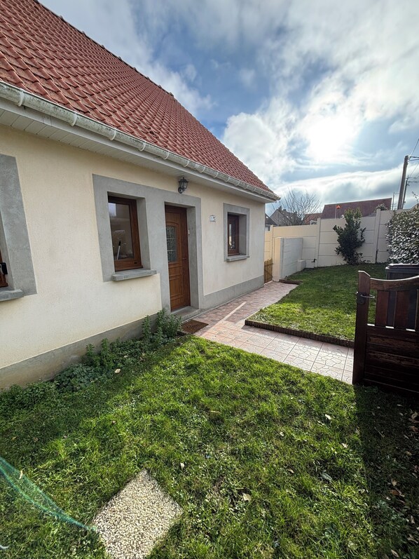 A two-story house with a red-tiled roof, a small front porch, and a well-maintained lawn. - Charming renovated house in Wissant (Wissant)