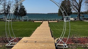 Une jetée en bois menant à un lac, surmontée d’une arche métallique.