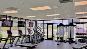 Et fitnesscenter med løbebånd, motionscykler og styrketreningsudstyr.