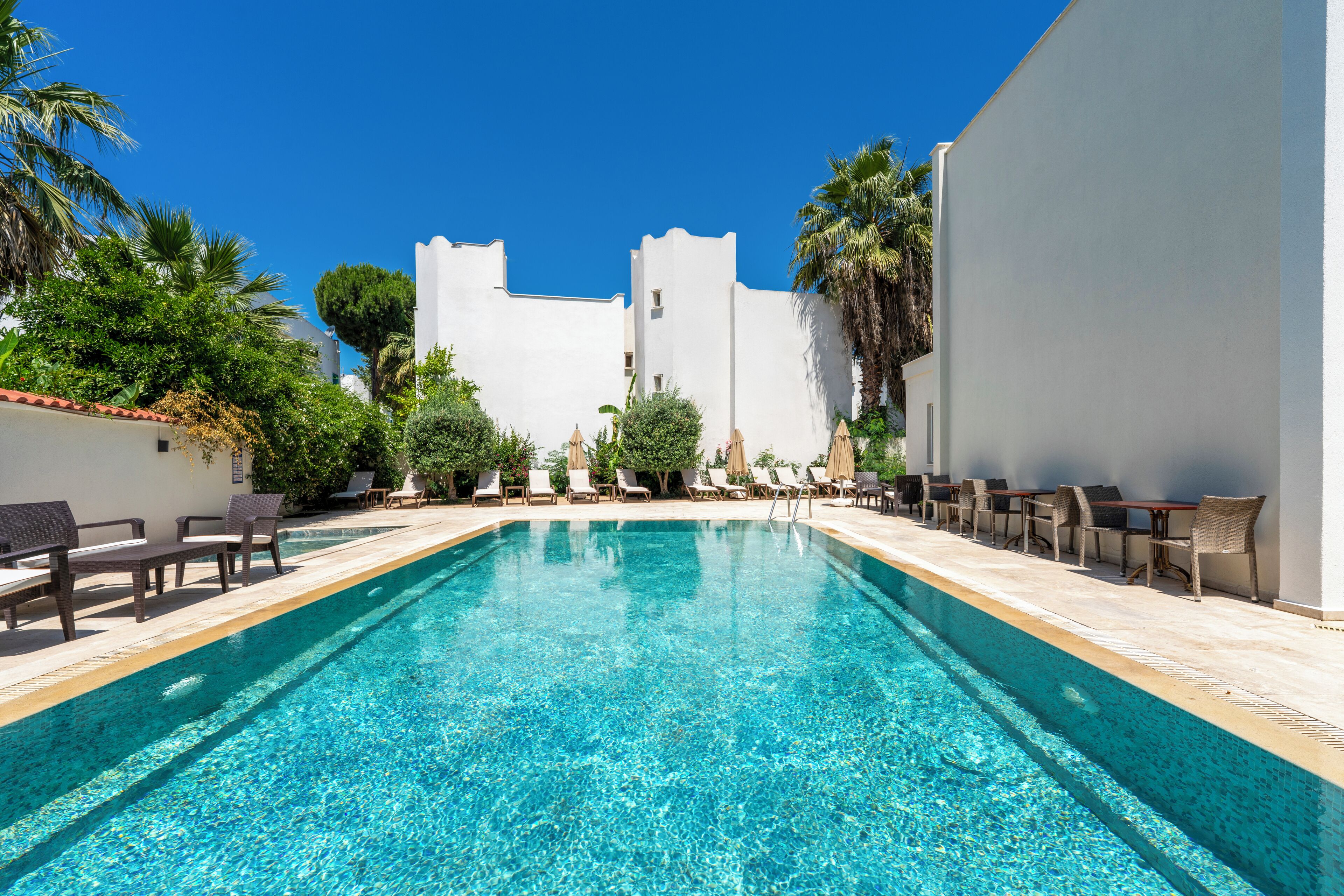 季節性室外游泳池，提供泳池遮陽傘和日光浴躺椅