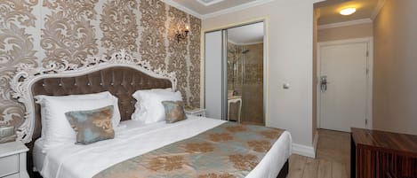 Un dormitorio con una cama grande, cabecera decorada y colcha estampada.